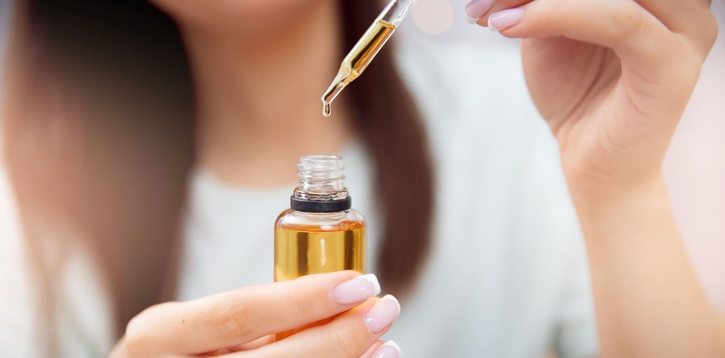 ragazza con boccetta di olio di ricino e contagocce